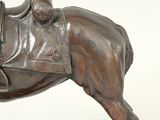 bronze statue of a horse with a saddle on it ' s back