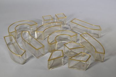 plusieurs morceaux de plastique transparent bordés d'or sur un fond blanc