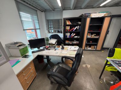 un bureau avec un ordinateur et une chaise dans une pièce