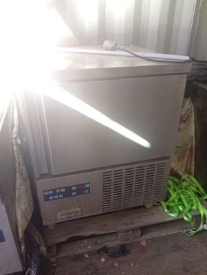 une photo d'un congélateur posé sur une palette à côté d'un tas de haricots verts