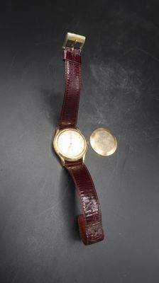 an image of a wrist watch and a coin on a table