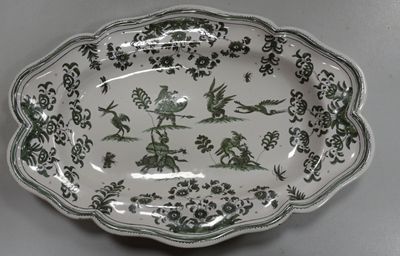 a green and white plate with birds and flowers on it