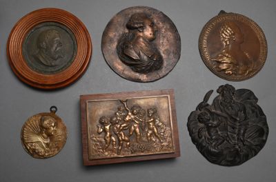 de nombreuses sculptures en bronze posées sur une table, avec la photo d'un homme