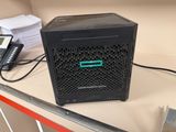 un petit ordinateur noir posé sur un bureau, à côté d'un téléphone