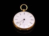 a gold pocket watch with roman numerals on the face