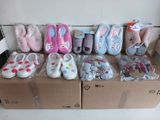 many pairs of baby shoes in a box on the floor