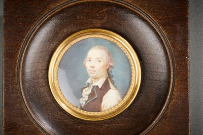 une photo représentant le portrait d'un homme portant un gilet marron