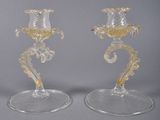 two clear glass candlesticks sitting on top of each other on a table