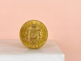 a gold coin sitting on top of a white pedestal