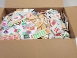 une boîte en carton remplie de timbres posée sur un lit