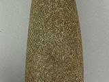un vase en pierre posé sur une surface blanche