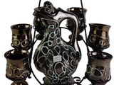 a black and white pitcher and cups on a stand
