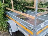 a small trailer with a cage on the back of it