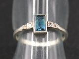 Gros plan sur une bague contenant une pierre bleue