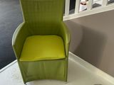 a green chair that is sitting in the corner of a room