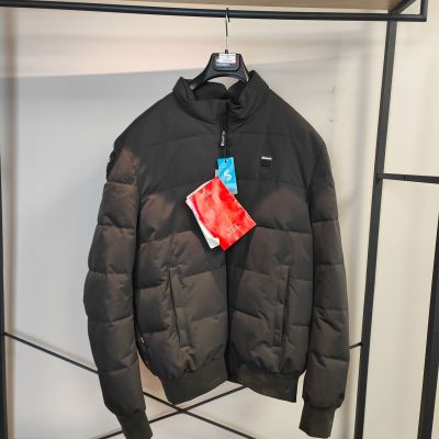 une veste noire suspendue à un portant dans un magasin