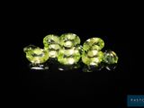 a close up of a bunch of green gems on a black surface