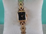 an image of a gold watch sitting on top of a pillow