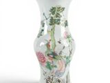 a white vase with a bird and flowers on it