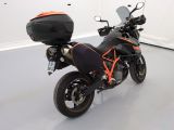 a black and orange motorcycle parked in a white room