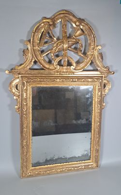 un miroir avec un cadre doré sur un mur blanc