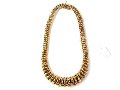 gros plan d'un collier en chaîne en or sur fond blanc