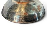 a metal object that is sitting on a white surface