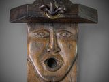 a wooden sculpture of a man with a hat on his head