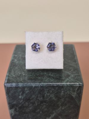 a pair of blue sapphire earrings sitting on top of a marble block
