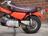 a red motorcycle parked in front of a brick wall