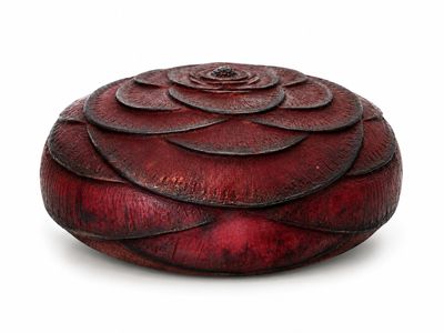 une boîte rouge ornée d'une fleur, posée sur un fond blanc