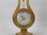 a gold clock sitting on top of a white table