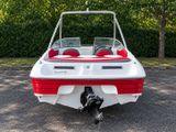 a white and red boat parked in a parking lot