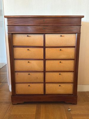 une commode en bois avec de nombreux tiroirs dans une pièce