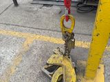 a yellow crane with a chain attached to it