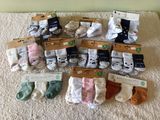 many pairs of baby socks that are on the floor