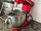 a red mixer sitting on a counter in a kitchen