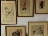 six dessins encadrés représentant des personnes dans diverses poses, accrochés au mur