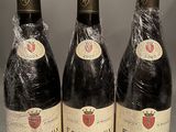 three bottles of wine are wrapped in plastic on a table