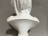 a white marble bust of a woman with a veil on her head