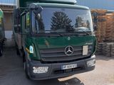 un camion vert garé devant un immeuble