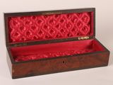 an open wooden box with red velvet linings on a white surface
