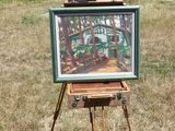 un tableau posé sur un chevalet au milieu d'un champ