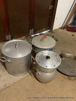 several pots and pans are sitting on the floor in front of a door