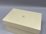 a white box sitting on top of a table with a clock on it