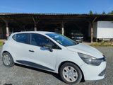 the small white car is parked in front of a building