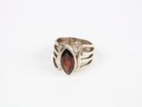 une bague en argent avec une pierre rouge au centre