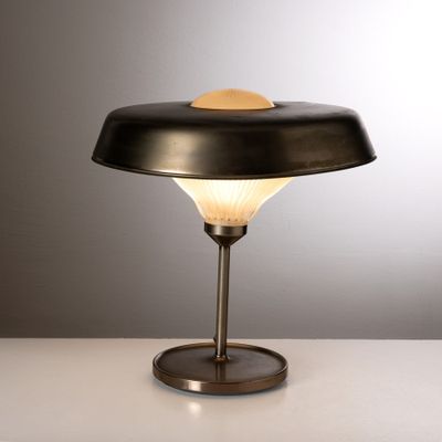 un gros plan d'une lampe posée sur une table, sur fond gris