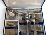 un service d'argenterie dans un coffret bleu posé sur une surface blanche