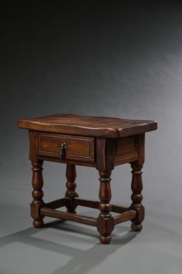 une vieille table en bois surmontée d'un tiroir